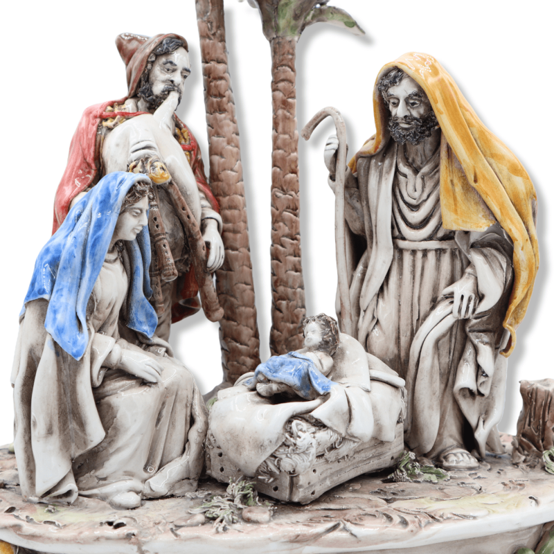 Large ceramic Nativity scene from Caltagirone, Holy Family with bagpiper and palm trees on a baroque base, approx. 37 x 