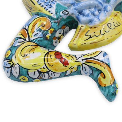Trinacria in keramiek Caltagirone, h 34 cm x ong. 33 l. barokke decoratie en fruit, groene achtergrond - 