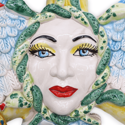 Trinacria in ceramica Caltagirone, con applicazioni di ruote di carretto e fiori, h 38 cm ca. Mod RP - 