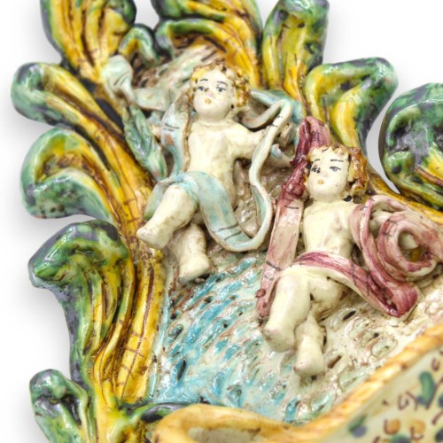 Acquasantiera in ceramica Caltagirone - h 25 x L 18 cm ca. con applicazioni di putti su fondo giallo-verde -  2