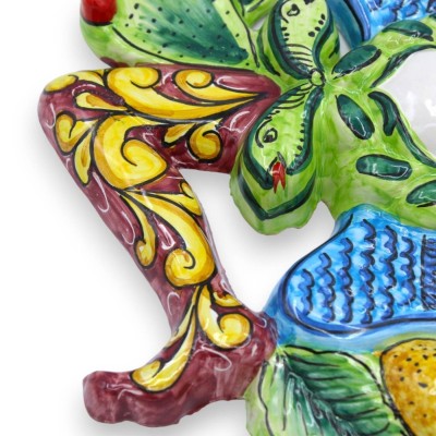 Trinacria in Sicilian ceramic - h 30 x 30 cm approx. Bordeaux background, fruit decoration and prickly pear blades - 