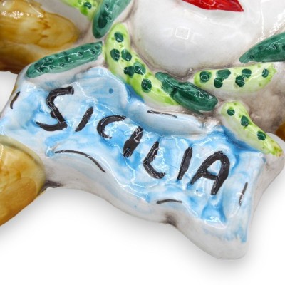 Trinacria in ceramica Caltagirone, con applicazioni di Pale ficodindia e fiori, h 36 cm ca. - 