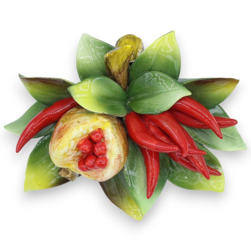 Bundel met compositie van pepers, granaatappel en bladeren in fijn keramiek, h circa 16 x 20 cm. - 