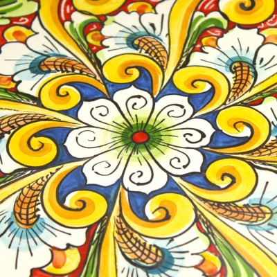Prydnadstallrik, i Caltagirone keramik, Ø ca 37 cm. barock dekoration och blomma på en röd bakgrund - 