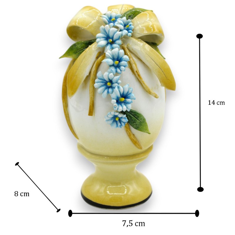 Oeuf avec tige, céramique fine, h 14 x 7 cm environ. Application de ruban jaune, chaîne de fleurs et de feuilles - 