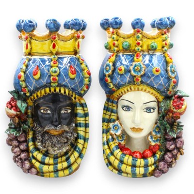 Sycylijskie głowy Maurów (para), wysokość ok. 32 cm. Korona, turban i owoce, ceramika z Caltagirone, niebieskie tło.