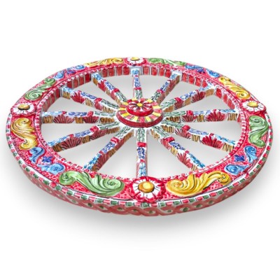 Roda de carroça siciliana, cerâmica de Caltagirone, Ø 50 cm aprox., decoração em relevo sobre fundo vermelho.