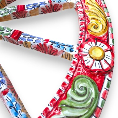 Roda de carroça siciliana, cerâmica de Caltagirone, Ø 50 cm aprox., decoração em relevo sobre fundo vermelho.