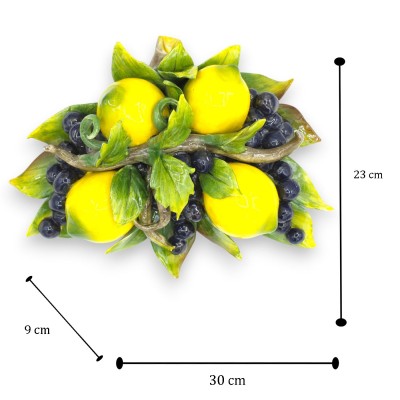 Arco colgante, de cerámica fina, de aproximadamente 23 x 30 cm de alto, compuesto por limones y uvas negras.