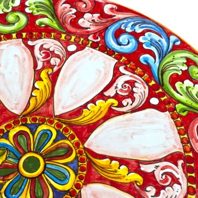 Ronde tafel van Etna-lavasteen, diameter 50 cm, smeedijzeren voetstuk, barokke en citroendecoratie, rode achtergrond.